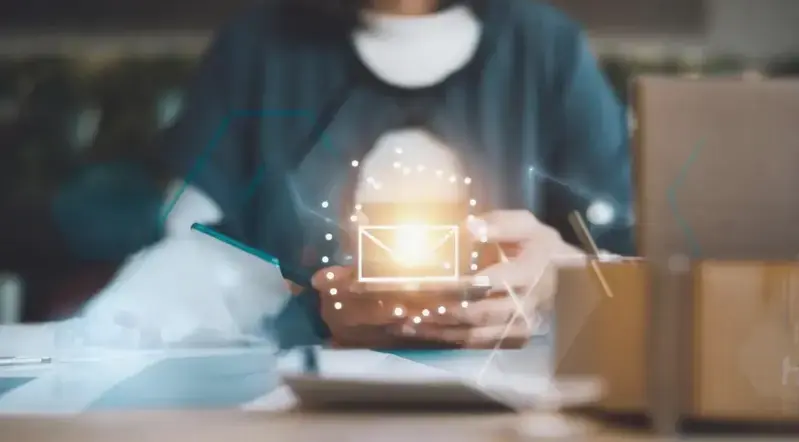 A sales professional engaging with ChatGPT on a laptop while drafting personalized emails.